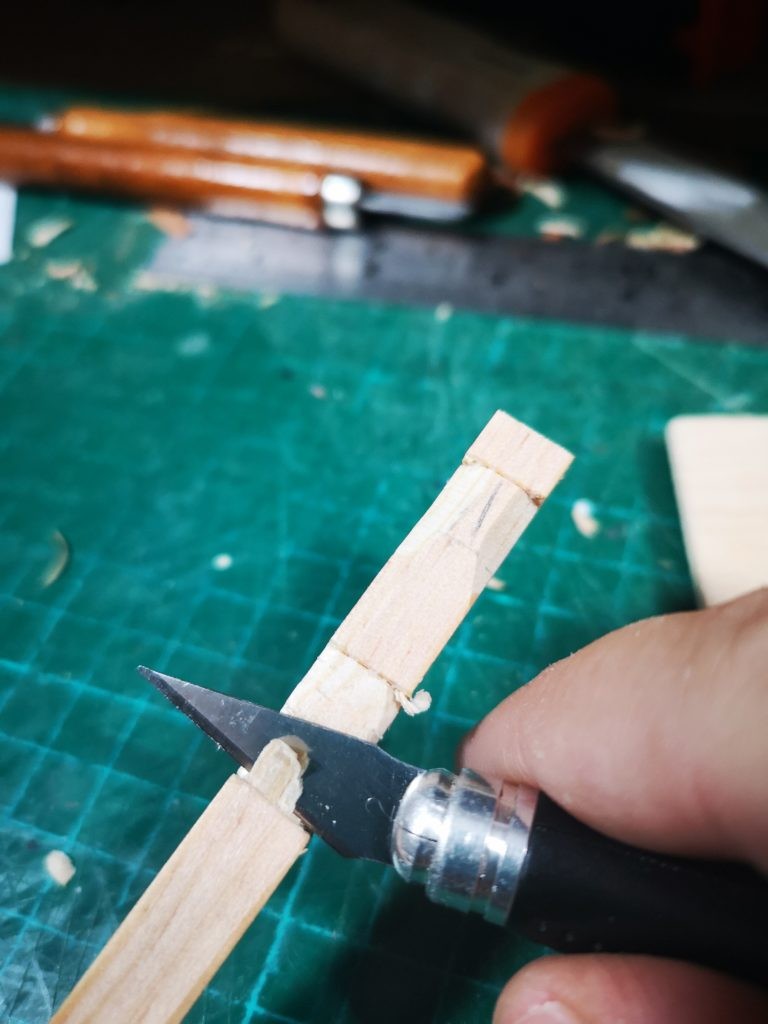 Corta con un cutter la figura en el liston de madera